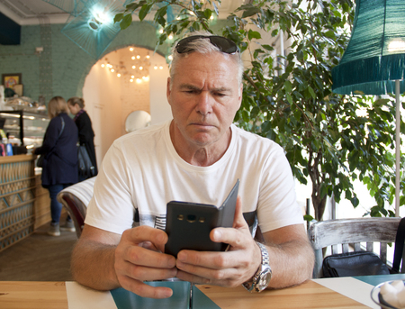 a man of age sitting in a cafeの写真素材