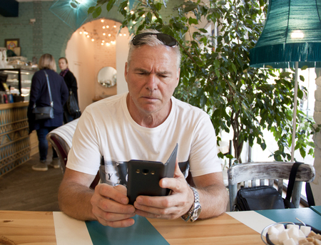 a man of age sitting in a cafeの写真素材