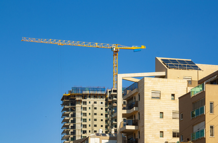 crane at the construction site against the blue skyの写真素材