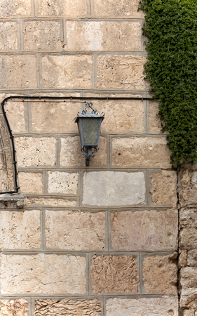 lantern on the stone wall of the buildingの写真素材