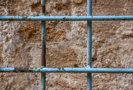 blue metal lattice against a stone wallの写真素材