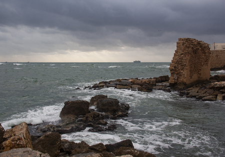 a picturesque view of the sea shore and the ancient fortress wall on a gloomy dayの写真素材