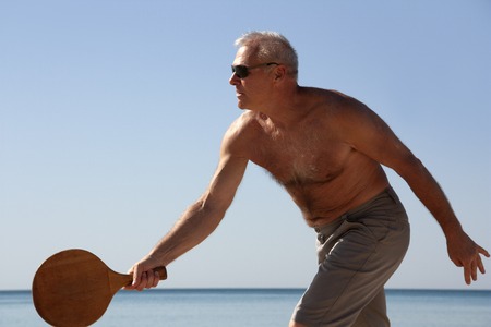 portrait of a man playing beach tennisの写真素材