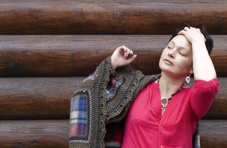 thoughtful woman combs her hair back with her hand