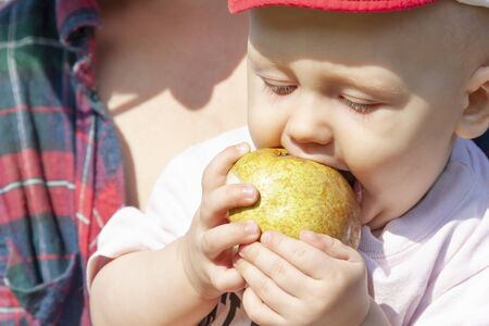 Baby tries to eat fruit for the first timeの写真素材