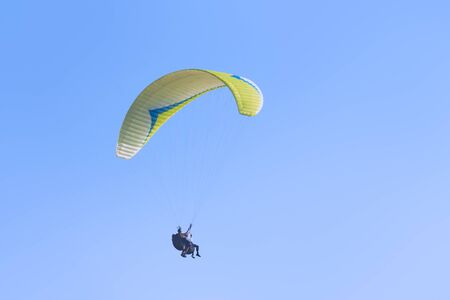 A man in a business suit experiences the thrill of flying a paragliderの写真素材
