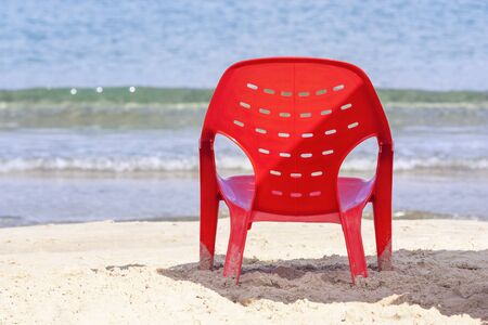Resort background with red chair at the waters edge