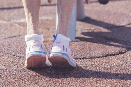 An aged woman doing exercises on the sports groundの写真素材