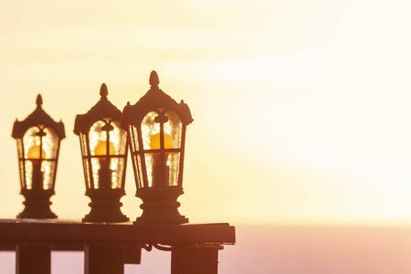 Silhouettes of glass lanterns on a soft background of a sea sunset
