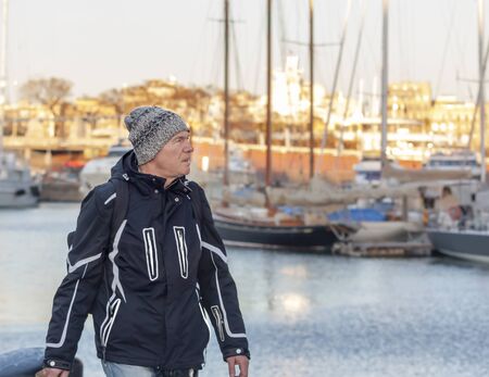 Tourist walking on the background of yachts in the port in winterの写真素材