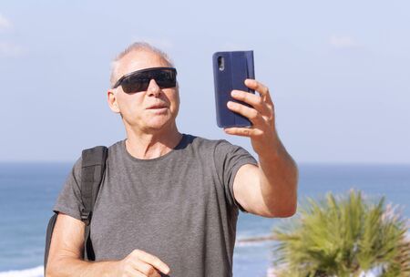 Tourist takes a selfie against the seaの写真素材
