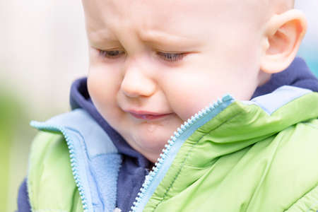 The portrait of a sobbing toddler against the background of nature Close-up