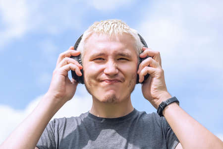 Guy with headphones standing against the skyの写真素材