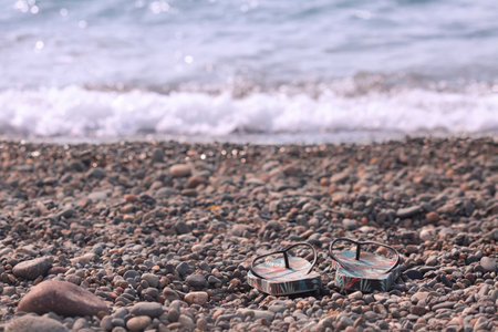 Flip-flops at the waters edge on a pebble beach