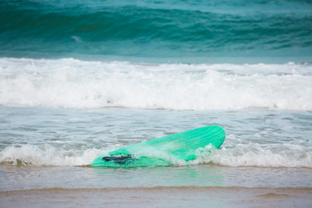 a surfboard washed ashore by a waveの写真素材