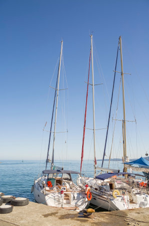 Sailboats moored to the pier against the blue sky on a sunny morningの写真素材