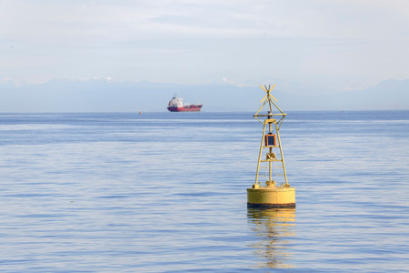 Yellow buoy close-up on the background of the sea with a ship in the distance
