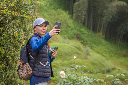 An attractive businesswoman with a backpack on her back takes a selfie against the background of...