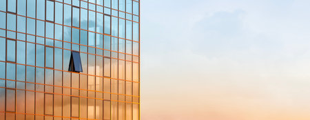 The glass wall of a modern building against the sky with the reflection of clouds on it during a...