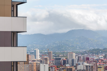 View of the balconies of a modern skyscraper against the backdrop of the city and mountains. Copy spaceの写真素材