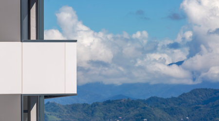 View of the balconies of a modern skyscraper against the backdrop of the city and mountains. Copy spaceの写真素材