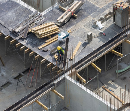 A carpenter installs a formwork for pouring a monolithic ceiling of an apartment building under constructionの写真素材