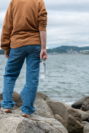 Person holding a plastic bottle of waterの写真素材