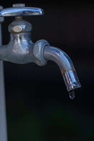 Drops of water falling from a faucetの写真素材