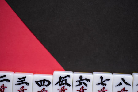Mahjong tiles lined up on a red and black backgroundの写真素材