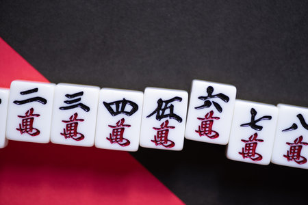 Mahjong tiles lined up on a red and black backgroundの写真素材