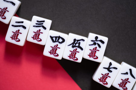 Mahjong tiles lined up on a red and black backgroundの写真素材