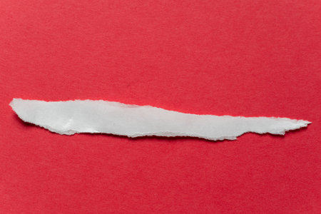 Torn white paper on a red backgroundの写真素材