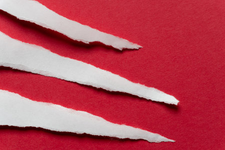 Torn white paper on a red backgroundの写真素材
