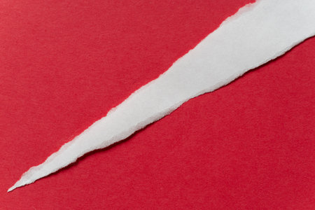 Torn white paper on a red backgroundの写真素材