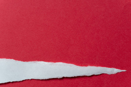 Torn white paper on a red backgroundの写真素材