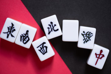 Mahjong tiles lined up on a red and black backgroundの写真素材