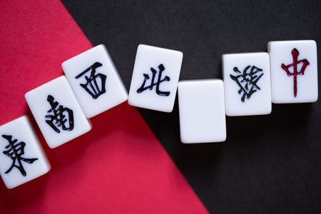 Mahjong tiles lined up on a red and black backgroundの写真素材
