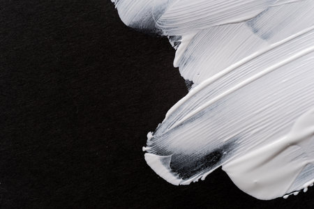 White paint on black construction paperの写真素材