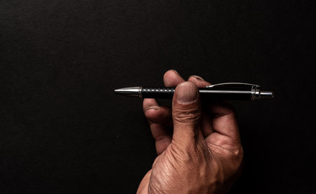 The hand of a person holding a ballpoint penの写真素材