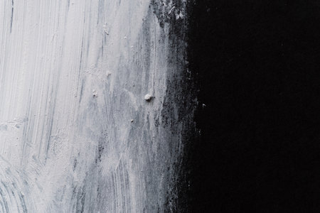 White paint on black construction paperの写真素材