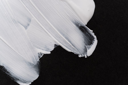 White paint on black construction paperの写真素材