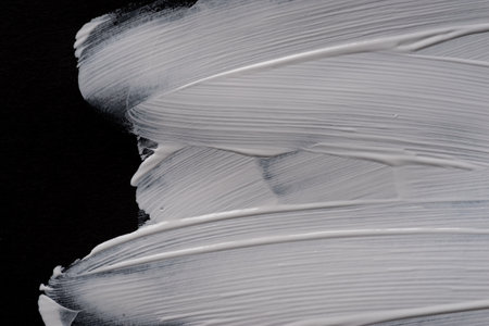 White paint on black construction paperの写真素材