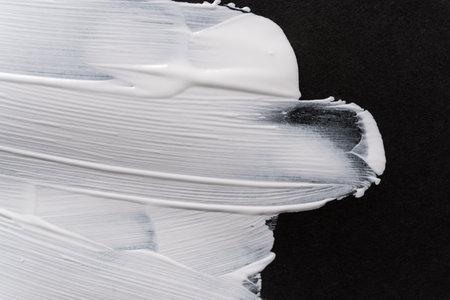 White paint on black construction paperの写真素材