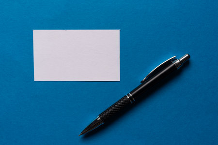 A note and ballpoint pen on a blue backgroundの写真素材