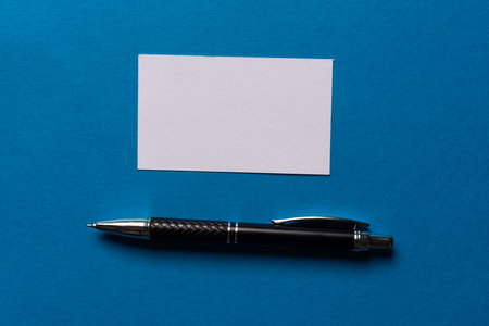 A note and ballpoint pen on a blue backgroundの写真素材