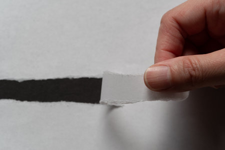 Person tearing up white paper