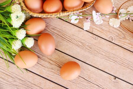Eggs in the basket on wooden backgroundの写真素材