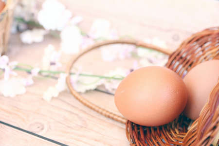 Eggs in the basket on wooden backgroundの写真素材