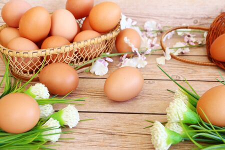 Eggs in the basket on wooden backgroundの写真素材