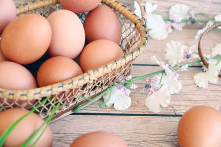 Eggs in the basket on wooden backgroundの写真素材